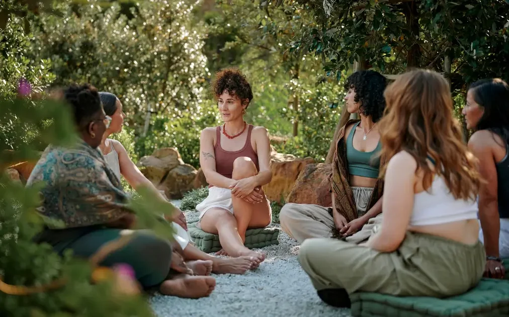 Women sitting together in a garden wellbeing circle